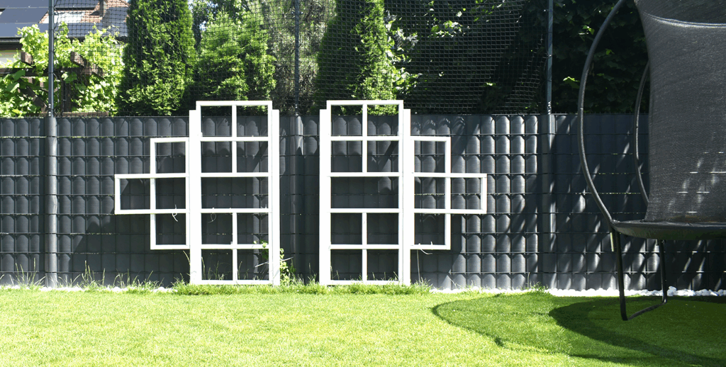 Oryginalna podpora na pnącza w ogrodzie minimalistycznym na wrocławskim Oporowie, wykonana z metalu i drewna.