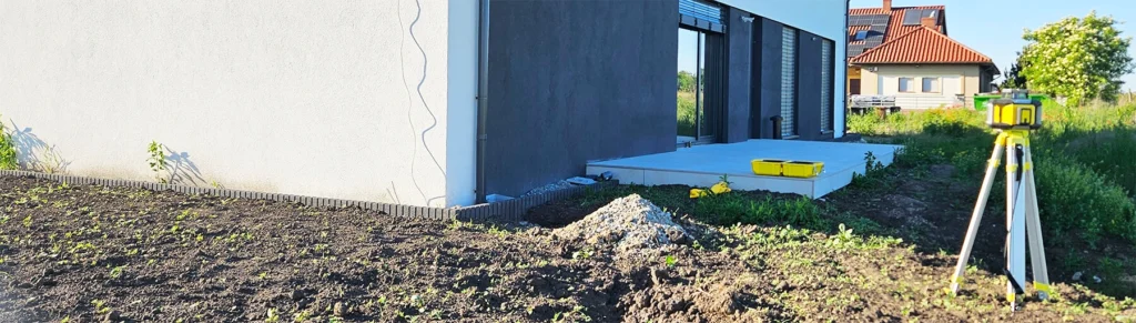 Projektant ogrodów podczas spotkania na działce analizuje teren i rozmawia z inwestorem o projekcie ogrodu